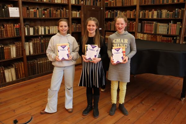 Die drei Siegerinnen freuen sich über ihre Urkunde und einen Buchpreis: Marieke Stoltz von der Ernestinenschule (3. Platz) Victoria Schiemann vom Johanneum zu Lübeck  (1. Platz) und Emma Frederieke Frenz von der Thomas-Mann-Schule (2.Platz).