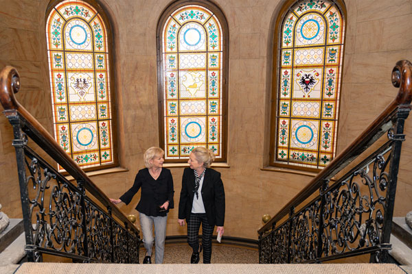 Marita Marowski und Christiane Hunold auf dem Weg in die Belétage. Hohe Fenster versorgen das Treppenhaus mit Licht. Fotos: Arved Appartements
