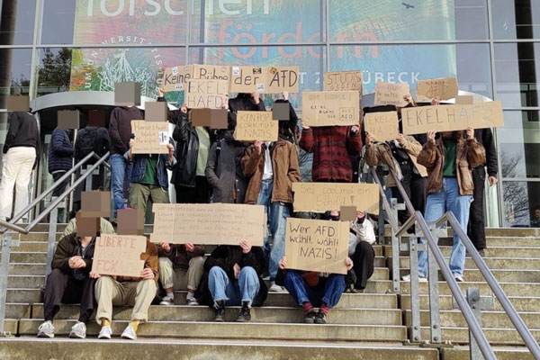 Studierende mit Schildern vor dem Audimax der Universität zu Lübeck mit Aufschriften wie “Keine Bühne der AfD”, “Kein Popcorn für die AfD”, “Hansestadt bleibt Nazifrei” oder “Studis gegen Rechts”. Foto: Initiative