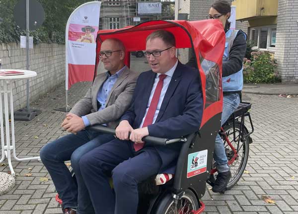 Senator Sven Schindler und Bürgermeister Jan Lindenau bei einer Probefahrt mit der Rikscha der Bürgerinitiative Brolingplatz. Foto: Hansestadt Lübeck.