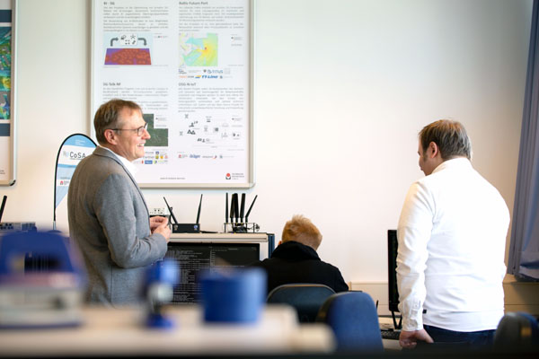 Prof. Horst Hellbrück bespricht mit seinen Mitarbeitern Björn Sievers und Swen Leugner im Labor die nächsten Schritte für das 5G-Campusnetz. Foto: TH Lübeck