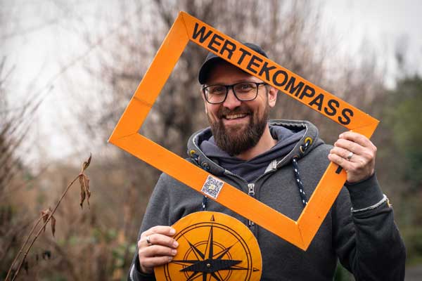 Filmemacher Mathias Hollaender zeigt eine Auswahl seiner orangefarbenen Rahmen aus den Stadtteilen St. Lorenz-Süd, St. Lorenz-Nord und Moisling. Foto: Archiv/Veranstalter