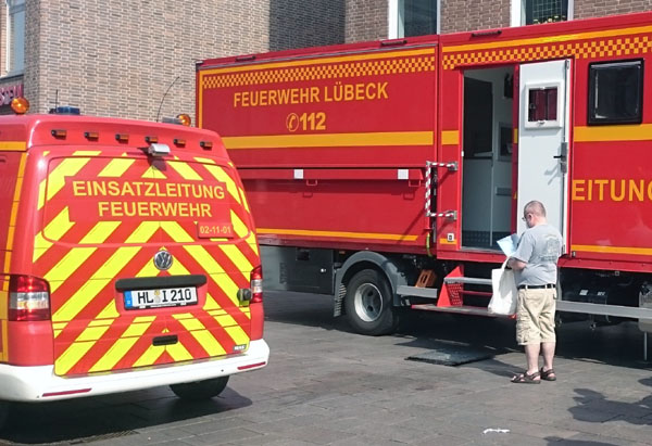 Ein kleiner Anreiz für Feuerwehr-Fans: Bis Samstag kann man sich am Kohlmarkt im neuen ELW2 der Feuerwehr impfen lassen. Foto: H.L., Grafik: Hansestadt Lübeck