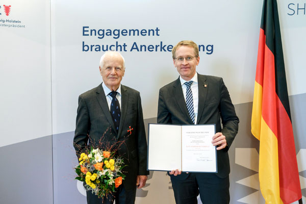 Ministerpräsident Daniel Günther (rechts) überreichte die Auszeichnung an den ehemaligen Rektor der FH Lübeck Professor Dr. Hans Wilhelm Orth. Foto: Frank Peter