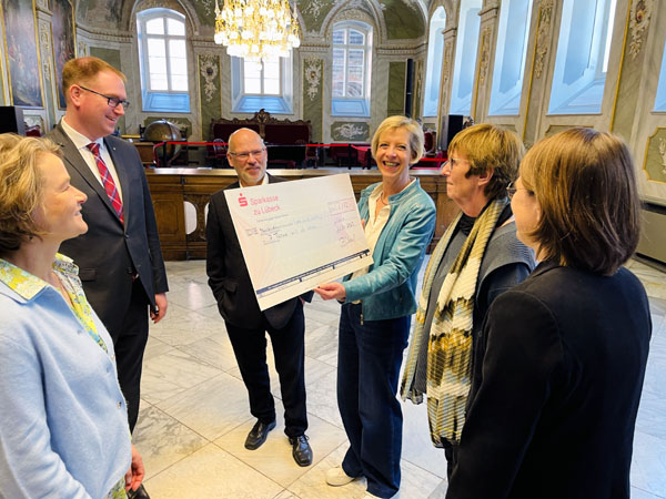 Stolz zeigt die Vorsitzende des Vereins Lübecker Stadtführer e.V. Petra Ulrich den Scheck mit dem Betrag von 1173 Euro. Foto: Steffi Niemann