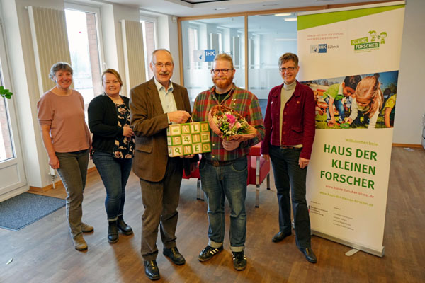 Dr. Ulrich Hoffmeister überreichte Yannik Fäscher von der UKSH Kita Unizwerge ein Präsent. Foto: Benjamin Tietjen/IHK zu Lübeck