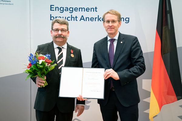 Andreas Henry Klüssendorff bekam den Verdienstorden von Ministerpräsident Daniel Günther überreicht. Fotos: Staatskanzlei SH