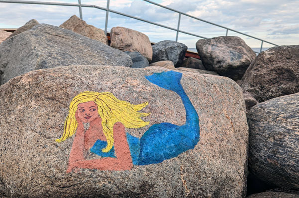 Eine waschechte Meerjungfrau räkelt sich auf einem Findling am Brodtener Steilufer. Fotos: Helge Normann