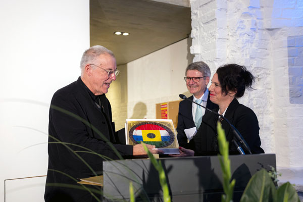 Max Schön und Sylvia Teske-Schlaak von der Possehl-Stiftung überreichten Matt Mullican auch eine Marzipan-Torte in Form seiner Blumenwiese am Dom. Foto: Agentur 54°