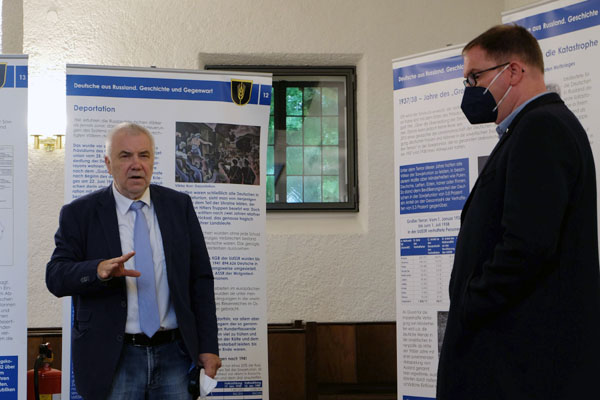 Egon Milbrod,  Vorsitzender der Ortsgruppe der Landsmannschaft der Deutschen aus Russland, zeigte Bürgermeister Jan Lindenau die Ausstellung. Foto: LmDR