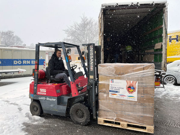 Die Paletten unter anderem mit medizinischen Verbrauchsmaterial werden in den Lkw verladen. Foto: UKSH